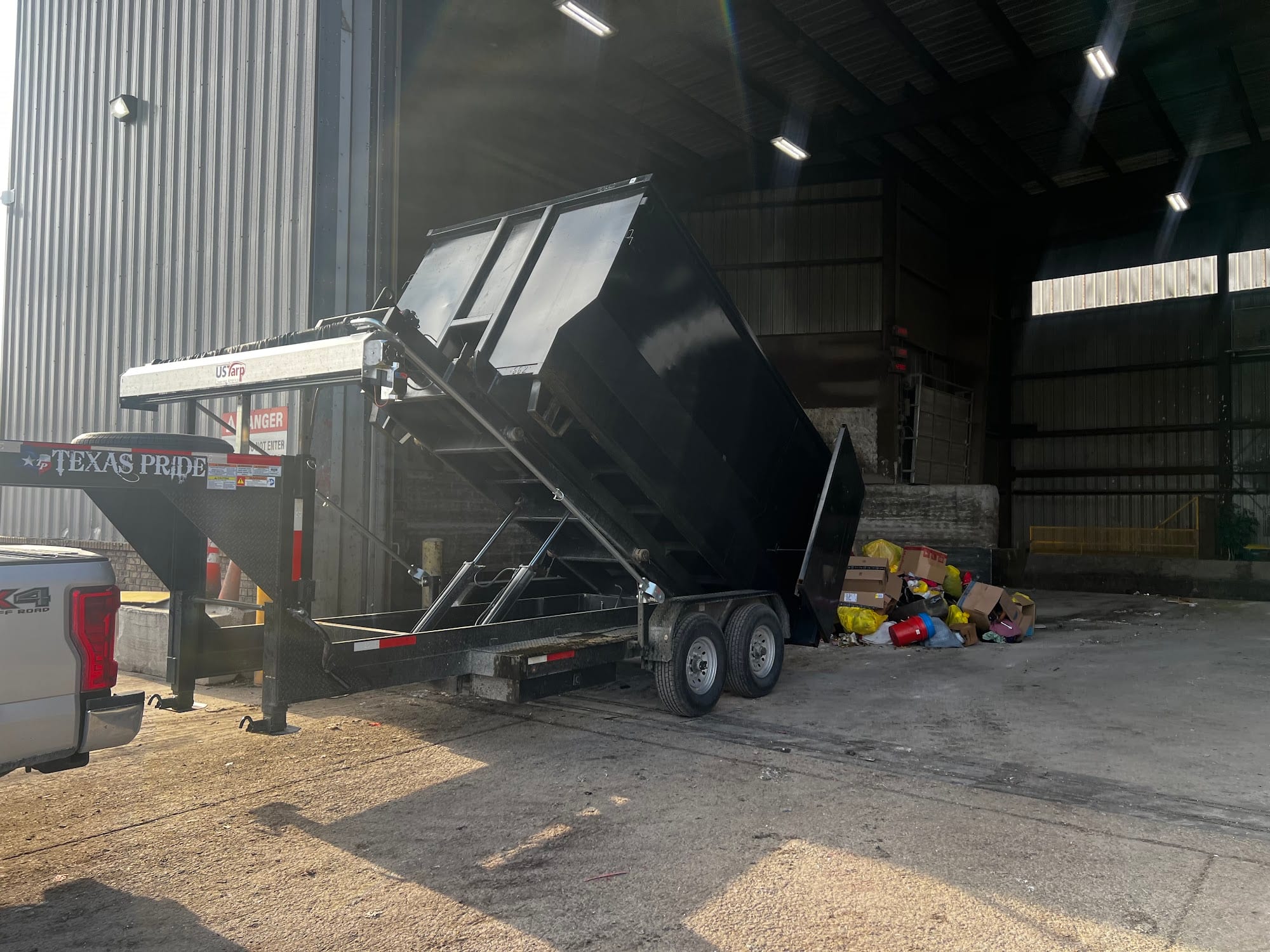 Dumpster trailer tipping in a driveway